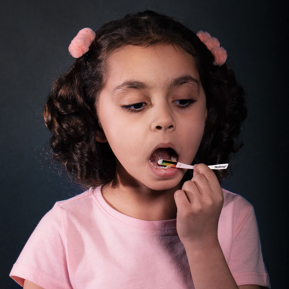 Girl using a NexTemp disposable oral thermometer for a temperature check