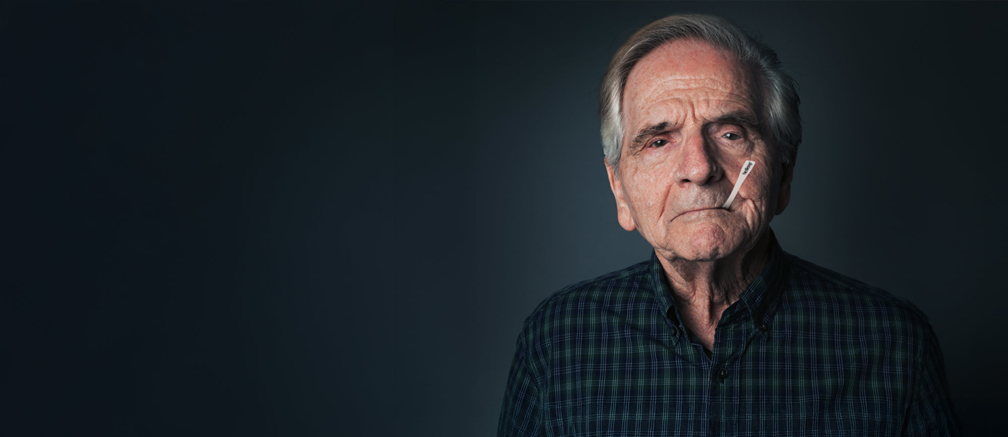 Older Man Using NexTemp Disposable Thermometer in Studio Portrait