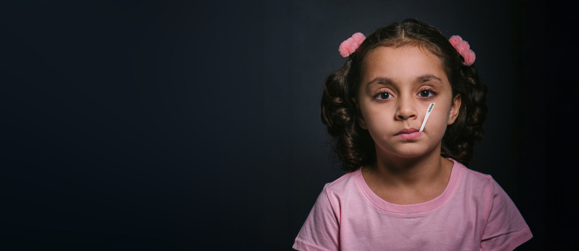 Young Girl Using NexTemp Disposable Thermometer Under Lip for Fever Monitoring
